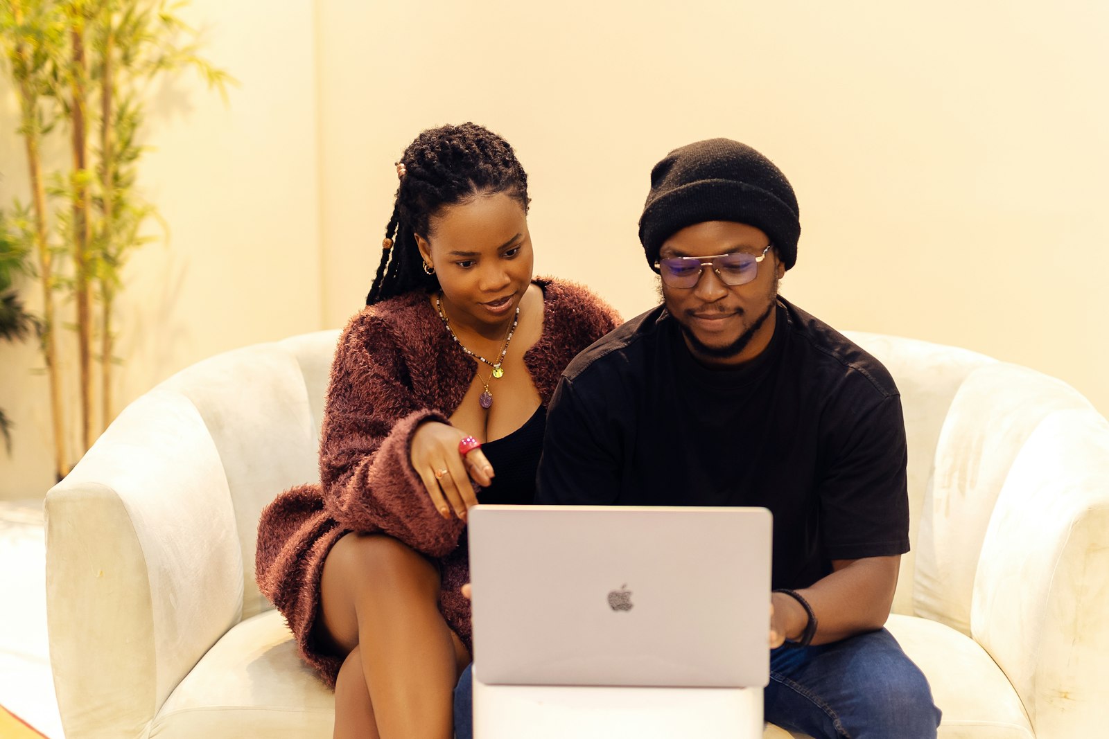 Couple sitting together on a sofa looking at a laptop