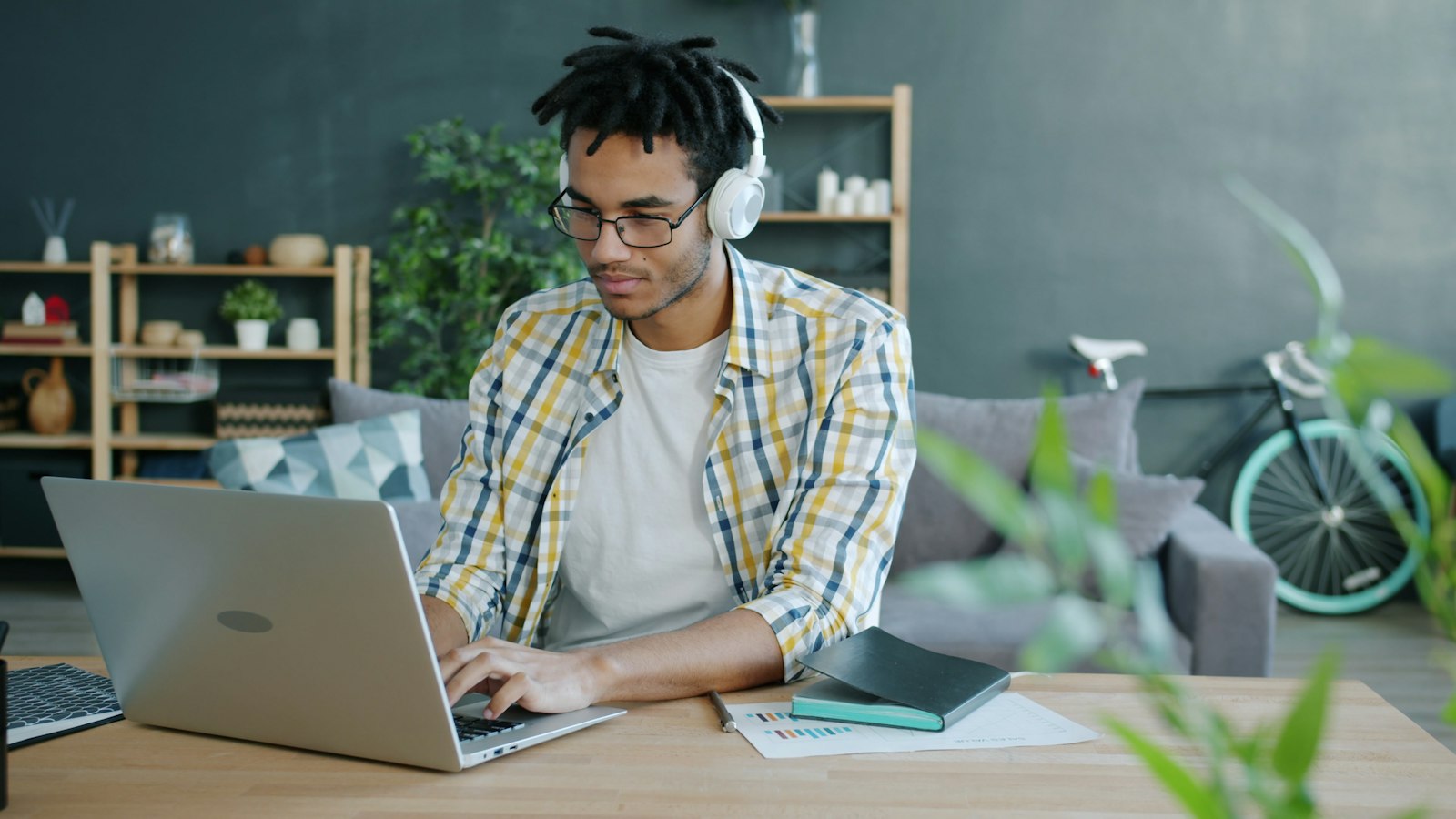 Man with headphones using a laptop at home