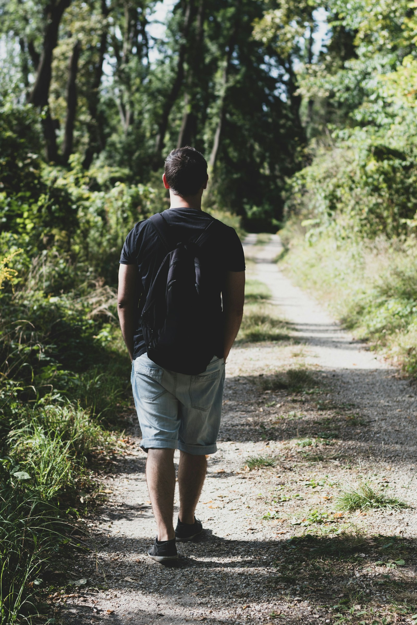 Man walking along a green path outdoors