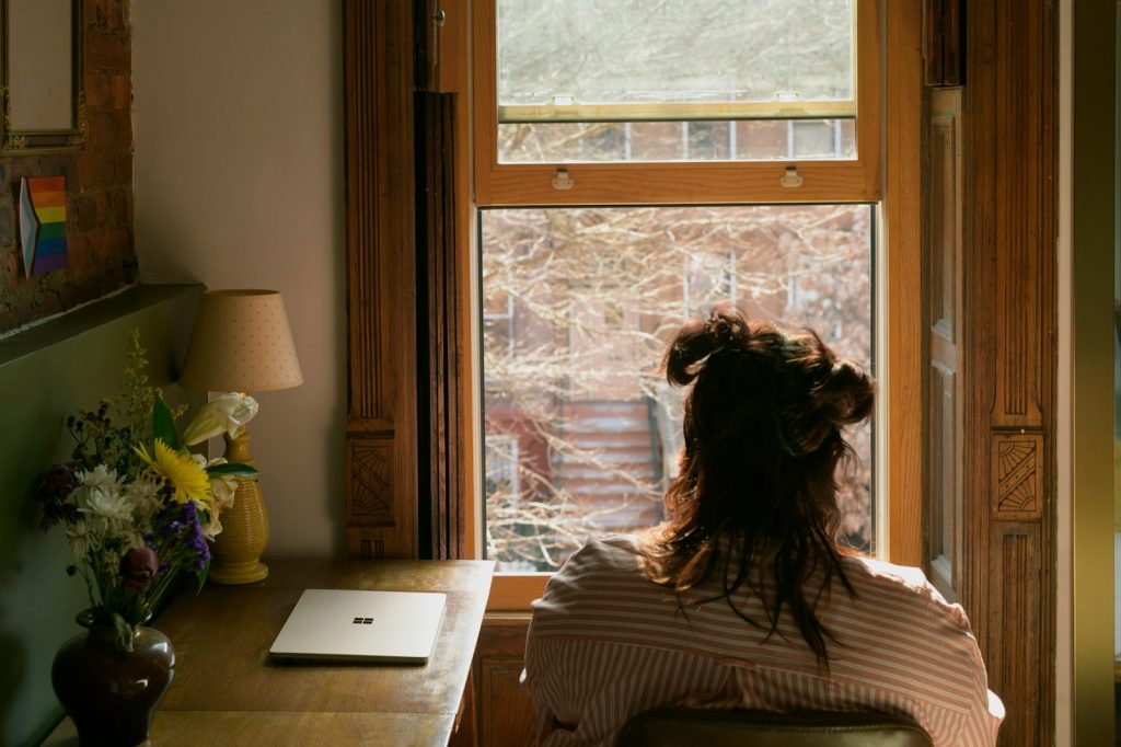 Woman sitting by a sunny window at home